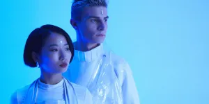 Futuristisches Foto eines jungen Mannes und einer jungen Frau, die im blauen Licht stehen
