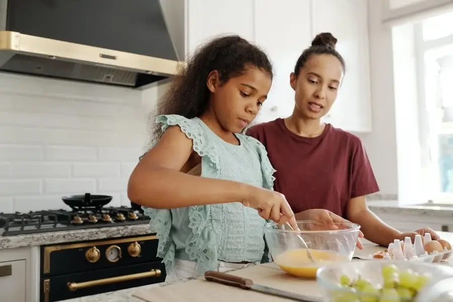 Girl mixing egg in mixing bowl