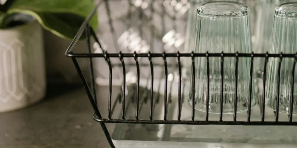 Tasses en verre dans une passoire à vaisselle en fil noir