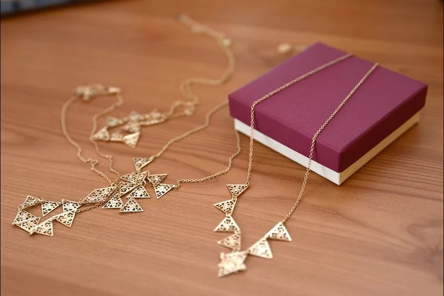 Gold necklace spread over a box
