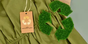 Kain katun ramah lingkungan berwarna hijau dan krem ​​dengan label daur ulang 100 persen