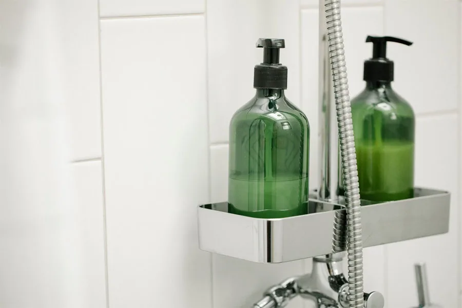 Green bottles on a stainless steel shower caddy