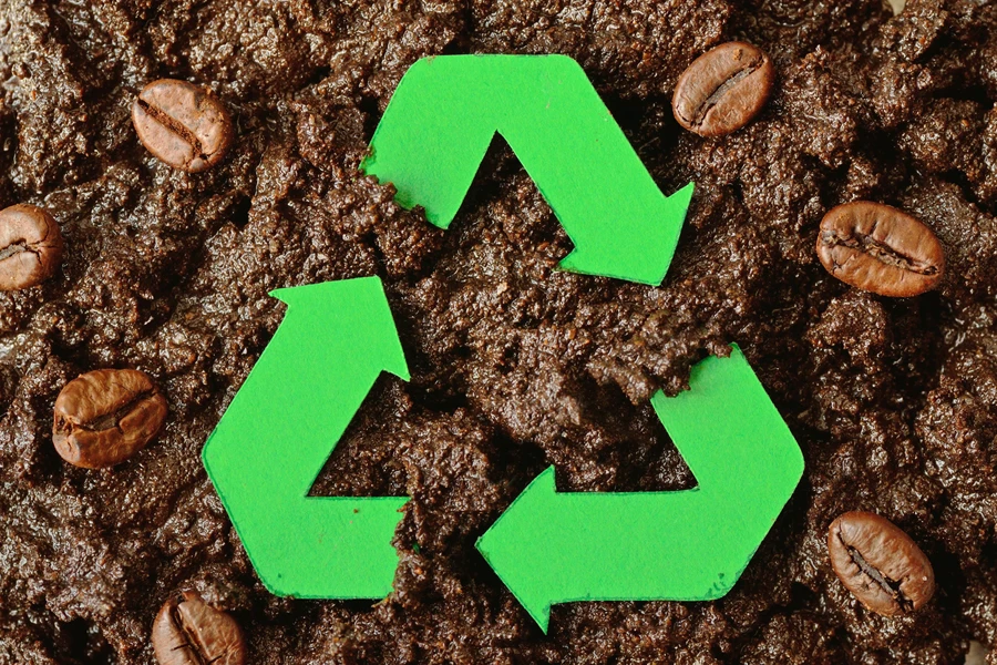 Símbolo de reciclaje verde sobre posos de café