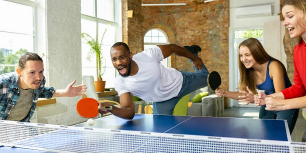Group of friends playing table tennis indoors