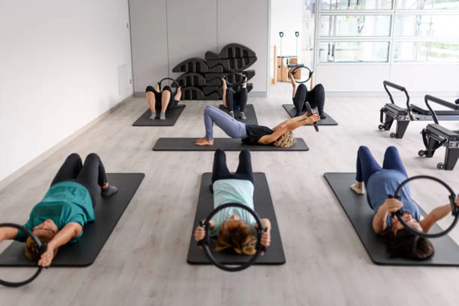 Esnemek için siyah yoga çemberlerini kullanan spor salonu dersi