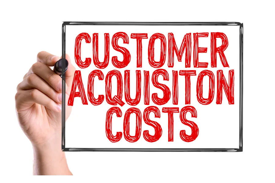 Hand writing “CUSTOMER ACQUISITION COSTS” on a white background