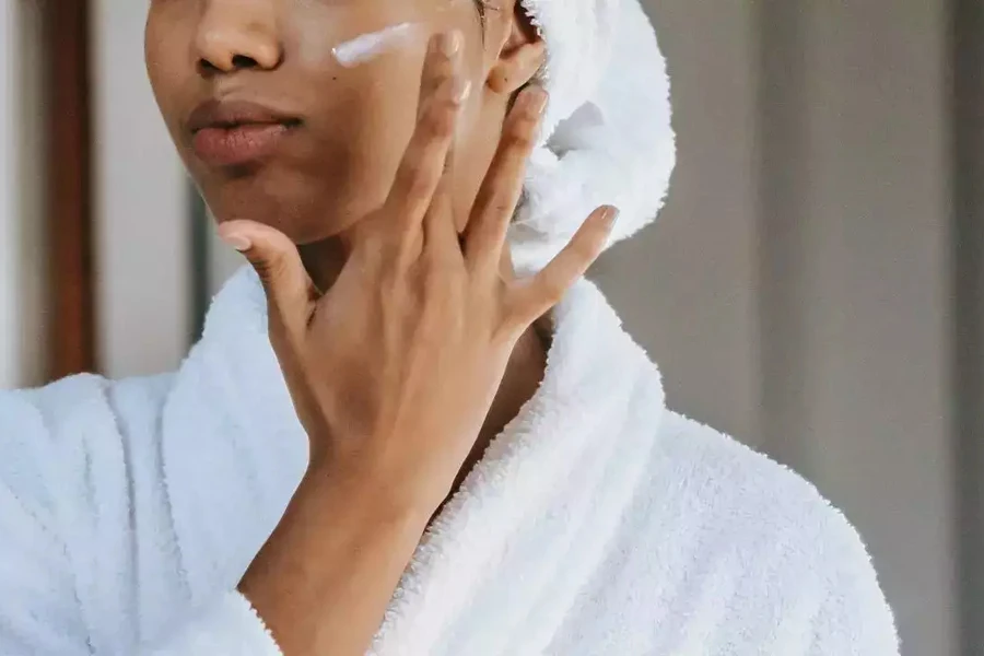 Lady applying a cream cleanser on her face