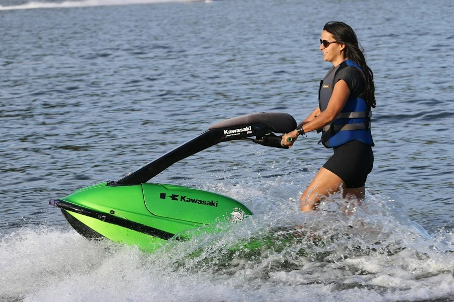 Signora che usa una moto d'acqua verde brillante