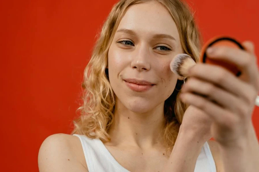 Dame, die einen Concealer mit einem Make-up-Pinsel verwendet