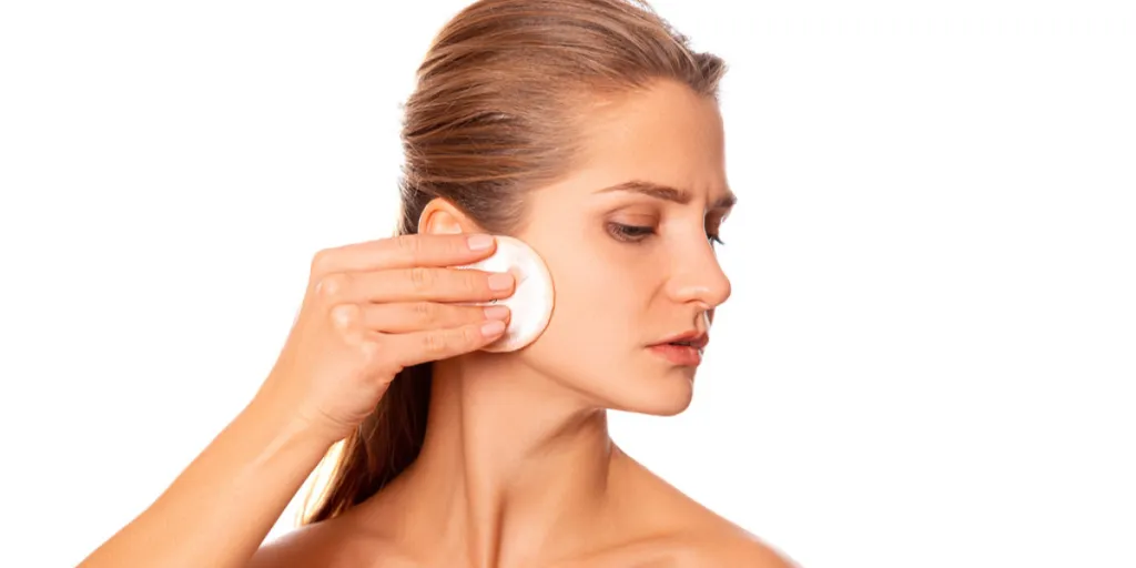 Lady using a facial cleanser with cotton pad
