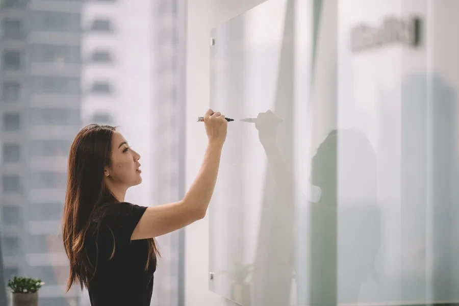 Lady writing on a whiteboard with marker pen