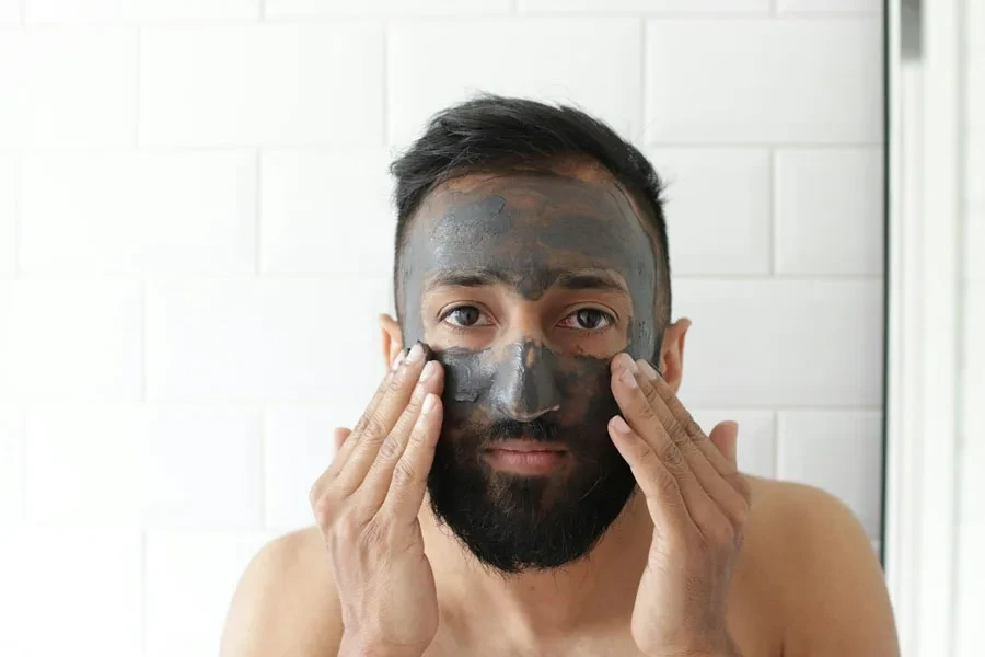 Homme appliquant un masque dans le miroir