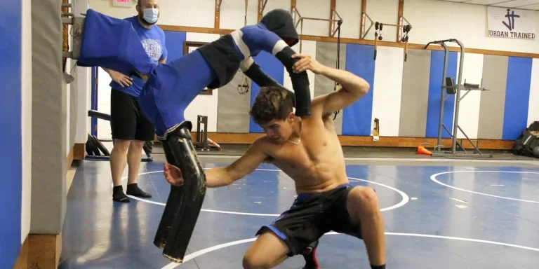 Man grappling with a wrestling dummy