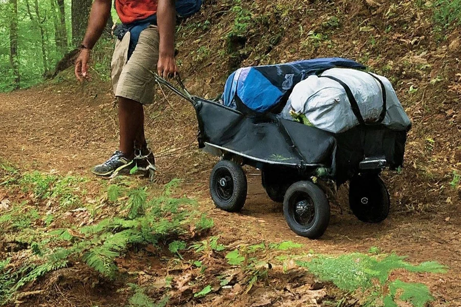 Man heading to a campsite while pulling a foldable wagon