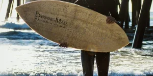 Man holding a wooden skimboard