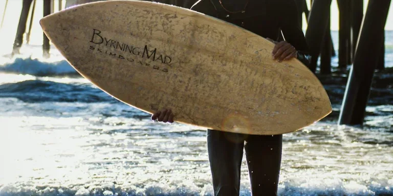 Man holding a wooden skimboard