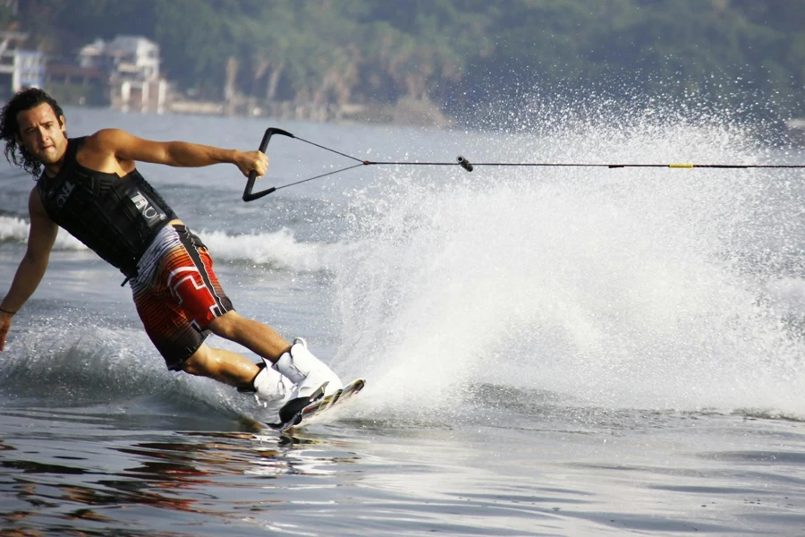 Man in red shorts and black tank top wakeboarding