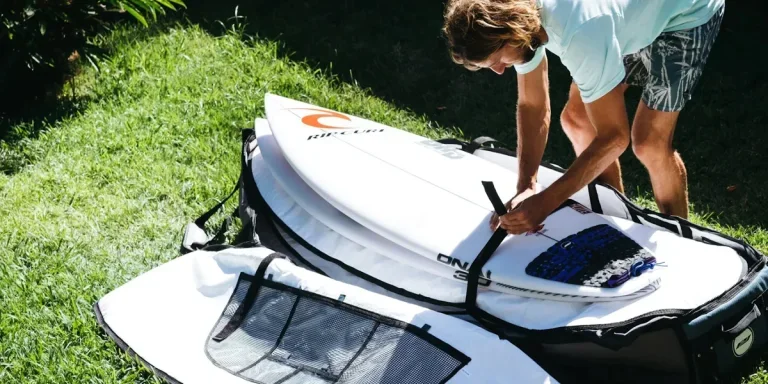 Man packing surfboards in a board bag