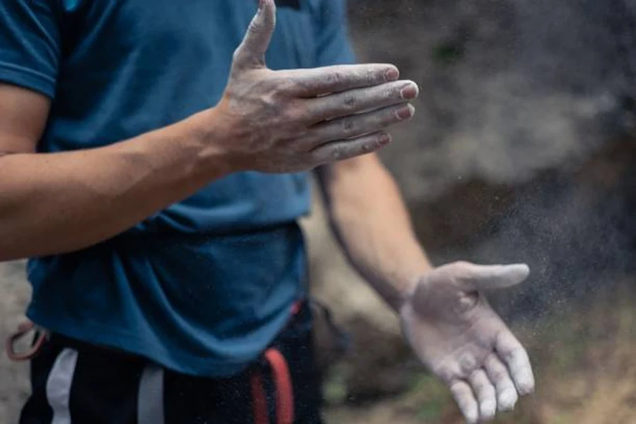 Man ready to climb with hands covered in chalk