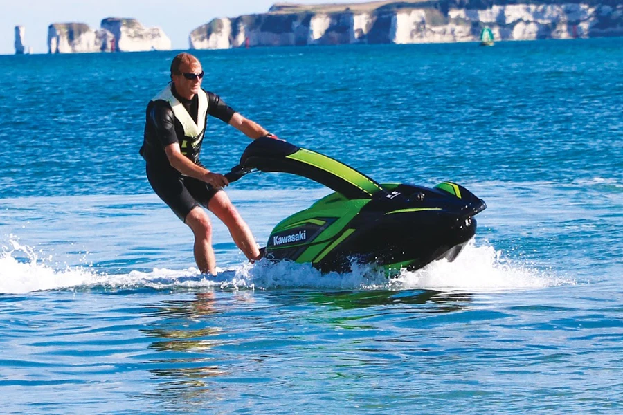 Uomo che guida su una moto d'acqua stand-up verde
