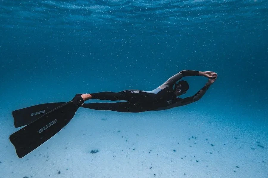 Hombre nadando gentilmente con aletas de buceo