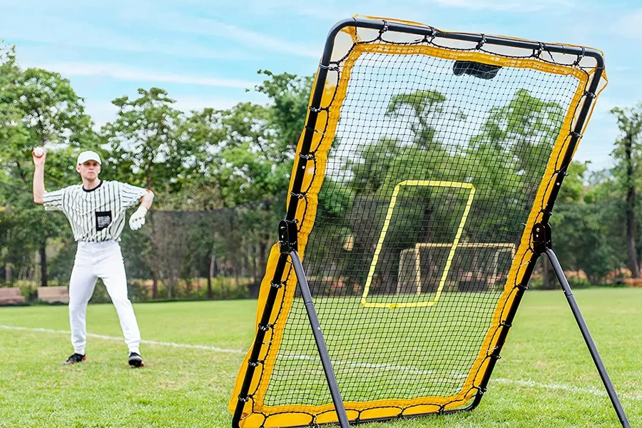 Man using a yellow softball rebounder