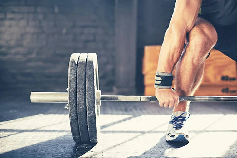 Man using chalk to help lift loaded barbell