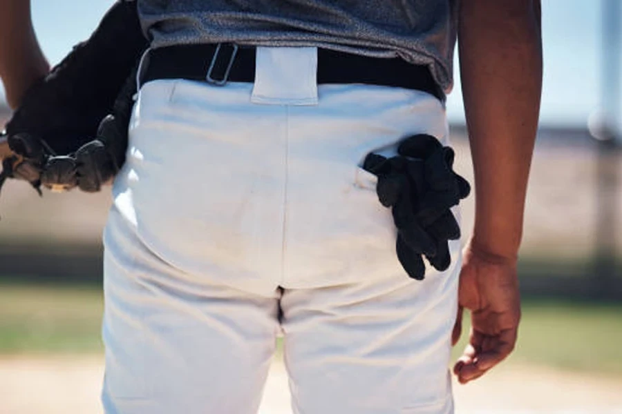 Man with glove hanging out of pocket of softball pants