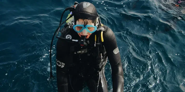 Man with scuba diving accessories after ascending