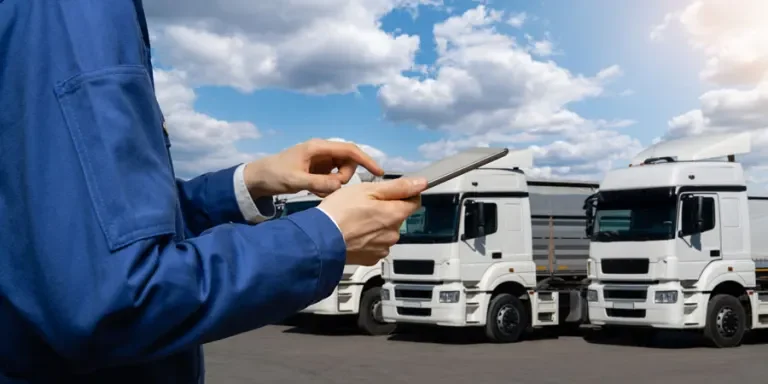 Manager with a digital tablet on the background of trucks