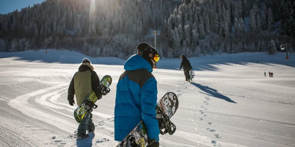 Many people on a sloped fully equipped for snowboarding