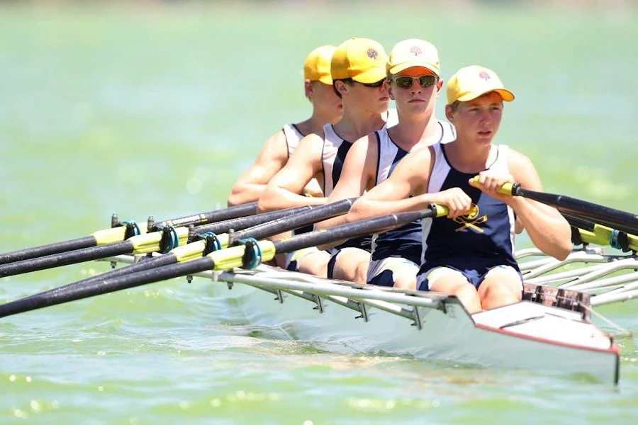 Multiple people in uniform rowing a boat