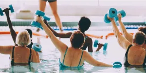Várias pessoas malhando em uma piscina