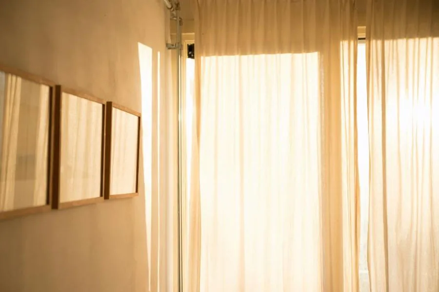 Luz natural que brilla a través de cortinas blancas transparentes.