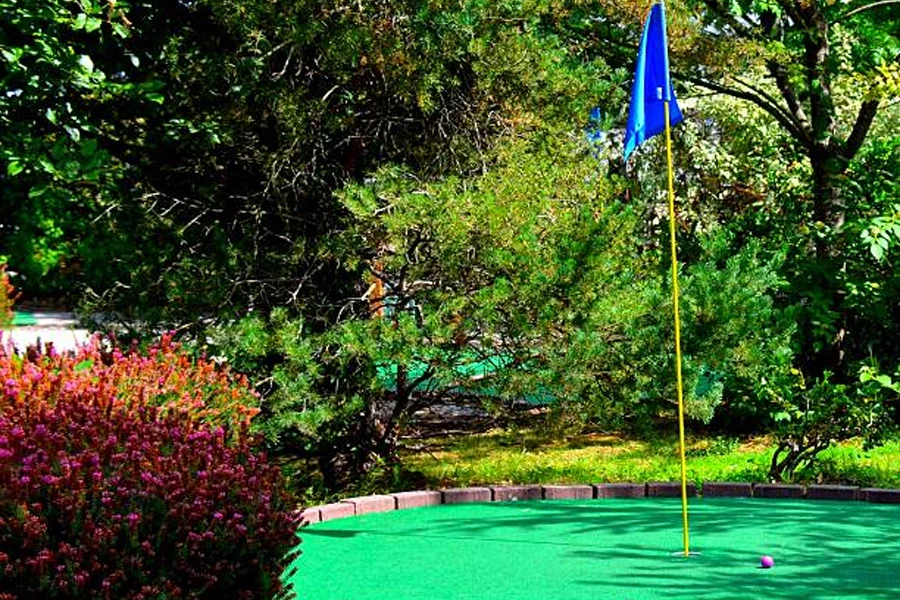 Outdoor artificial putting green with colorful golf balls on it