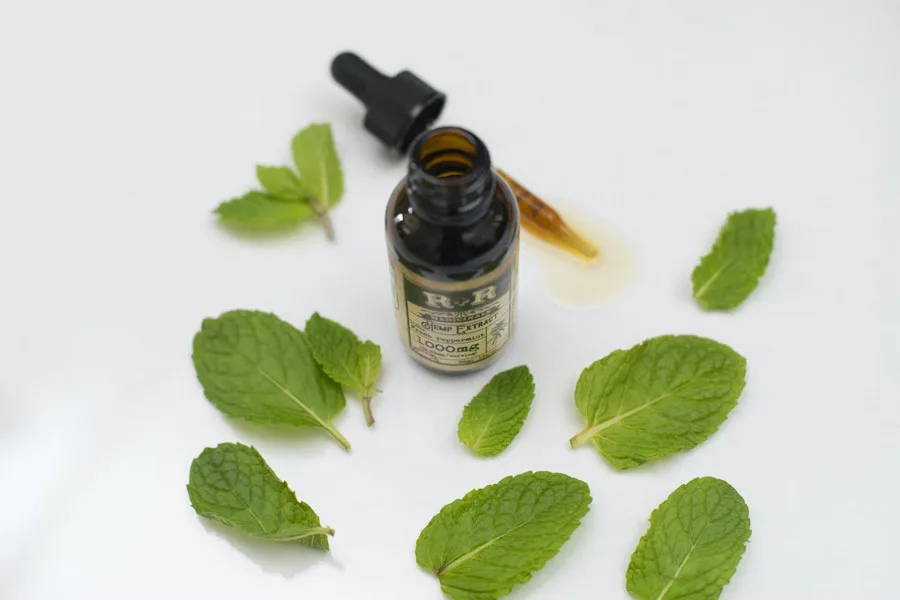 Peppermint leaves around a bottle of essential oil