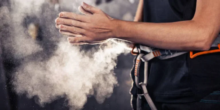 Person clapping hands while wearing powdered climbing chalk