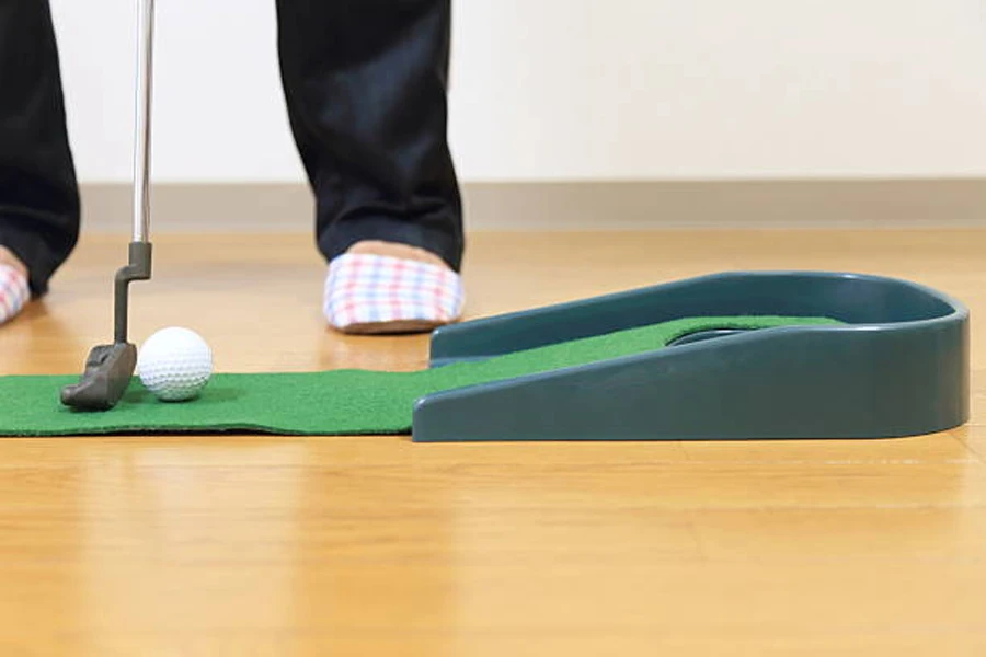 Person lining up ball on portable putting green