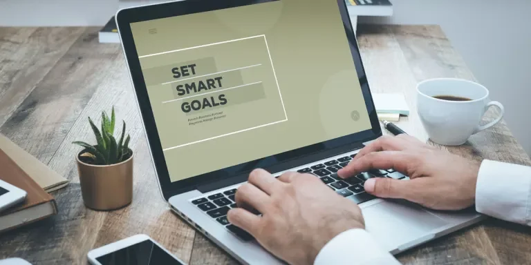 Person on computer with screen reading SET SMART GOALS