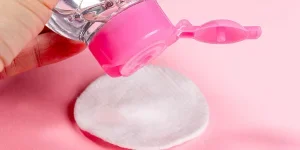 Person putting makeup remover on a cotton pad