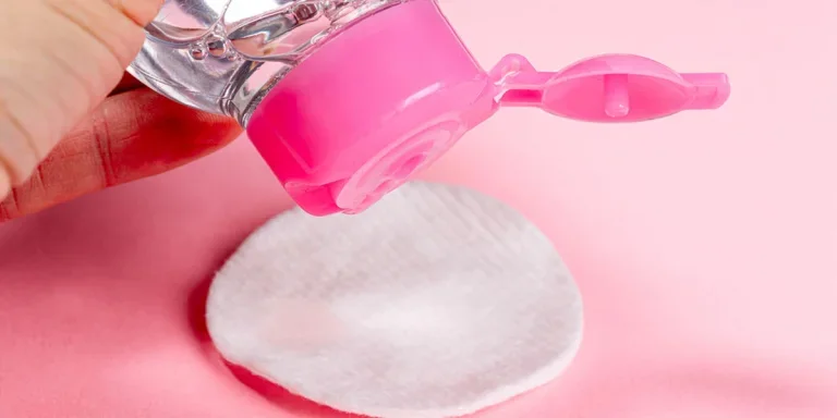 Person putting makeup remover on a cotton pad