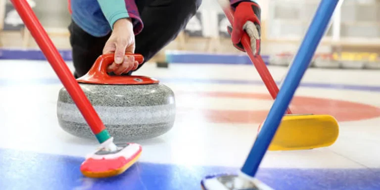 Person releasing curling stone with red handle on ice