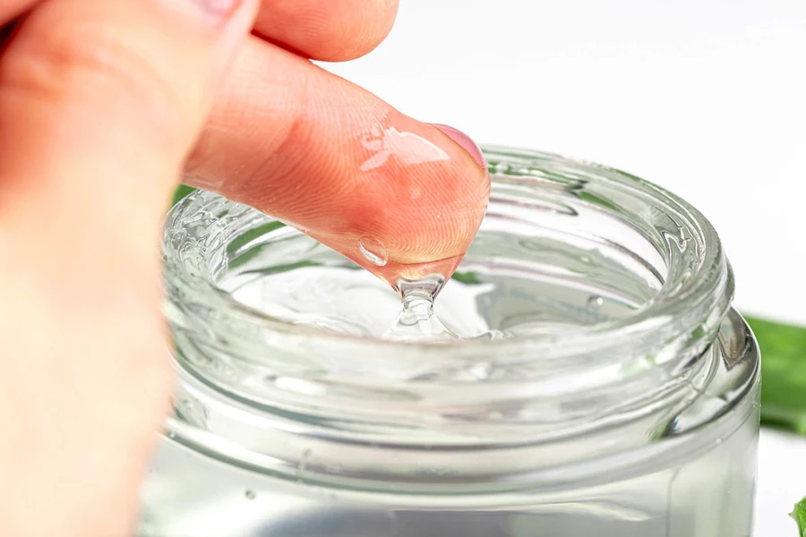 Person scooping aloe vera gel with finger