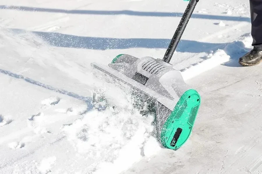 Person shoveling snow with an electric snow shovel