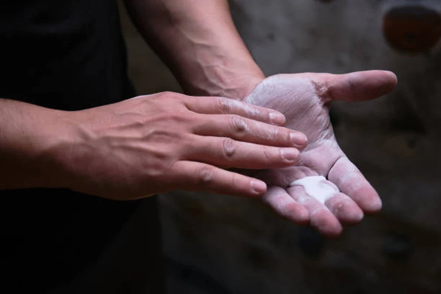 Person verteilt flüssige Kreide auf der Handfläche