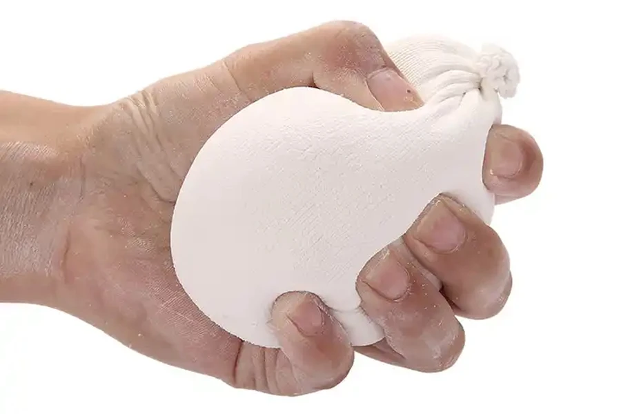 Person squeezing a white chalk ball in their hand