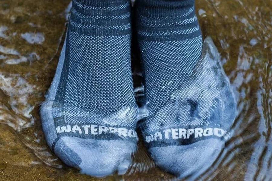 Persona in piedi in acqua con calzini da acqua