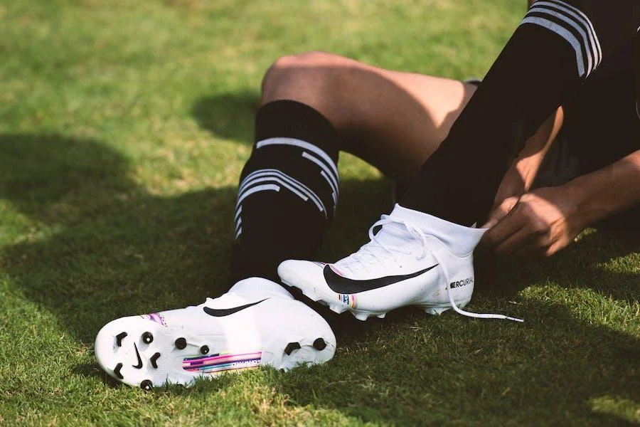 Person wearing a pair of white soccer cleats