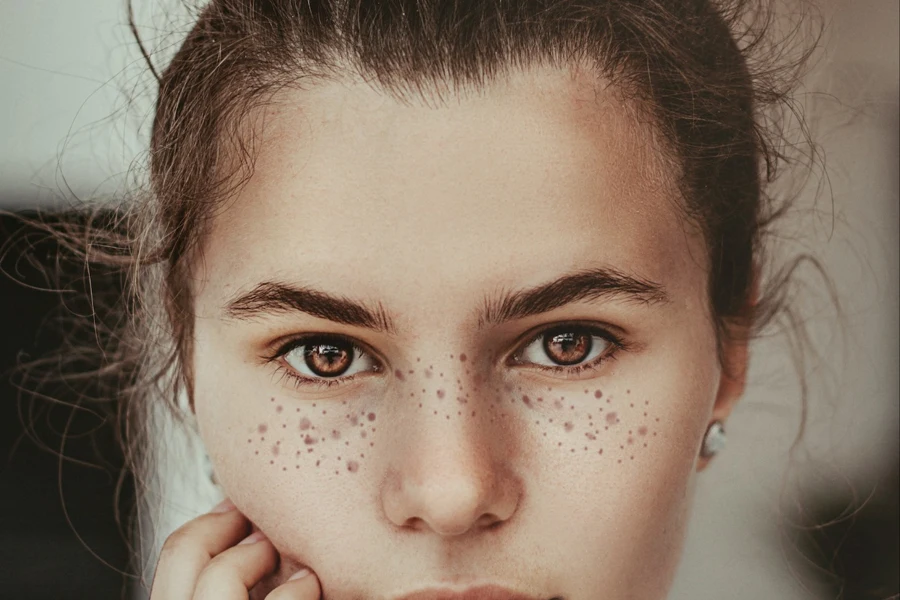 Person with brown eyes with faux freckles