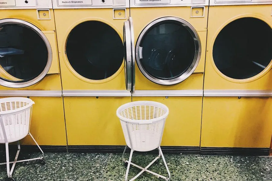 Plastic washing basket on wheels in laundromat